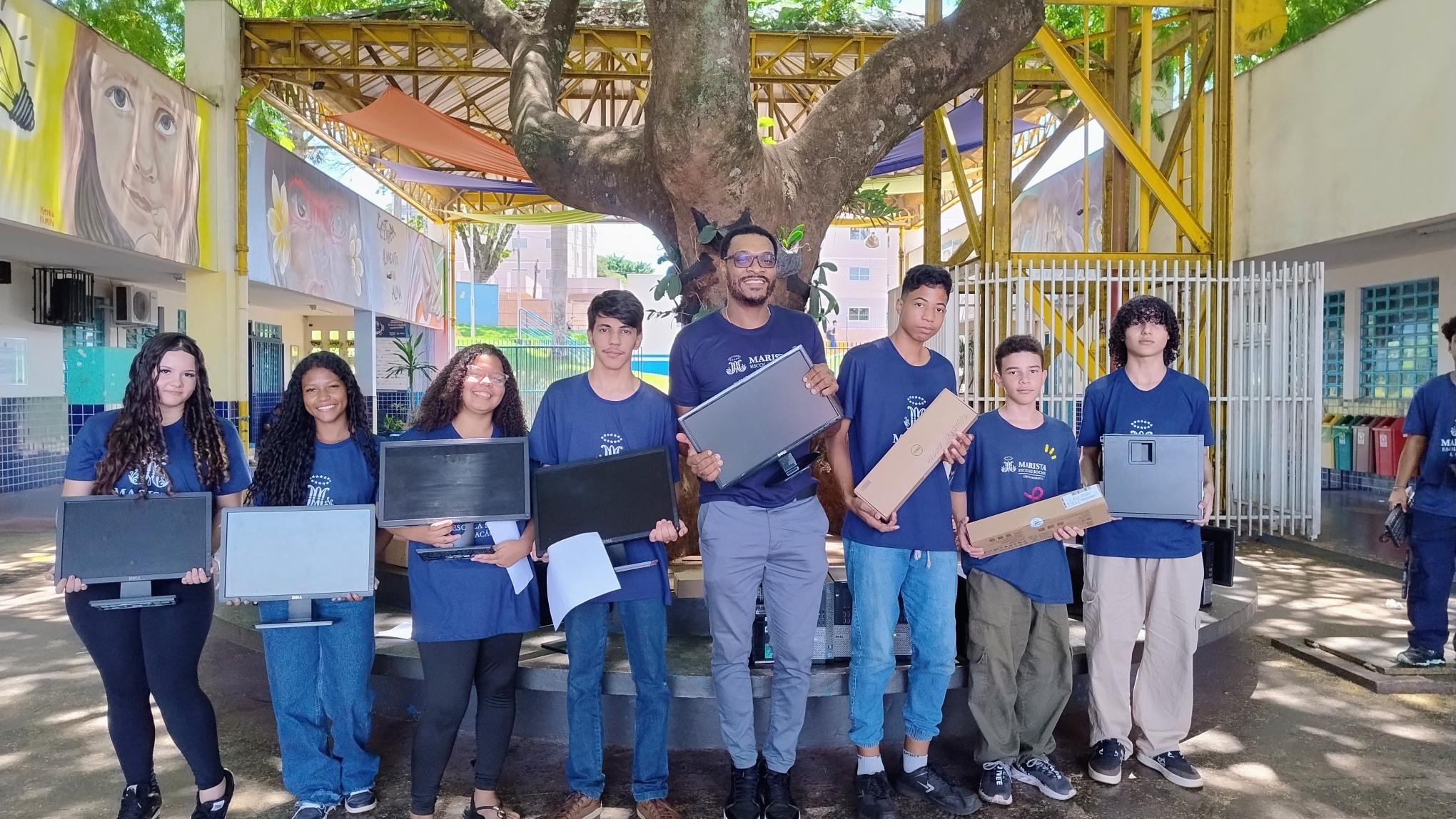 Estudantes recebendo computadores novos